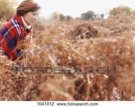 A woman sitting amongst dead ferns thinking View Large Photo Image Stock Image - A woman sitting amongst dead ferns thinking. Fotosearch
