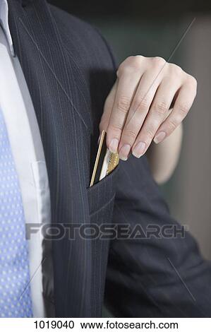 A woman taking a credit card out of a man's jacket pocket View Large Photo Image Stock Image - A woman taking a credit card out of a man's jacket pocket. Fotosearch
