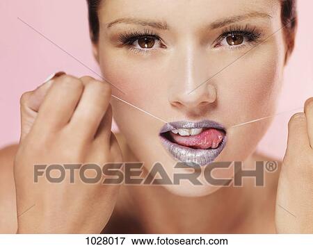 A woman using dental floss suggestively View Large Photo Image Stock Photo - A woman using dental floss suggestively. Fotosearch
