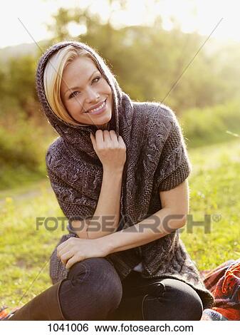 Stock Photograph - A woman wearing a shawl relaxing outdoors in the sun. Fotosearch