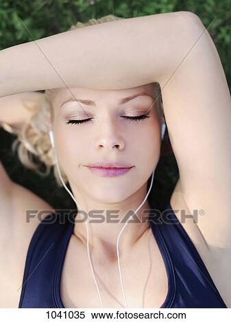A woman wearing earphones with her eyes closed, close-up, head and shoulders View Large Photo Image Stock Photography - A woman wearing earphones with her eyes closed, close-up, head and shoulders. Fotosearch
