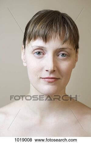 Stock Photo - A woman with bare shoulders staring intently into the camera. Fotosearch