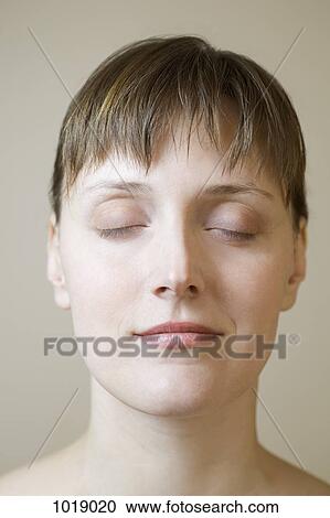 Stock Image - A woman with her eyes closed, close-up. Fotosearch