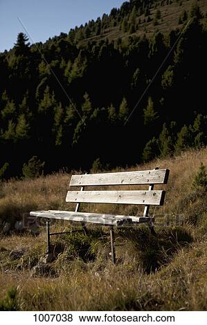 A wooden bench seat in a mountain setting View Large Photo Image Stock Photo - A wooden bench seat in a mountain setting. Fotosearch