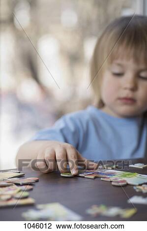 A young boy choosing a puzzle piece View Large Photo Image Stock Image - A young boy choosing a puzzle piece. Fotosearch