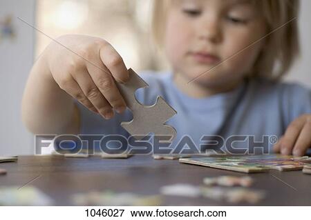 A young boy holding a puzzle piece View Large Photo Image Stock Photo - A young boy holding a puzzle piece. Fotosearch