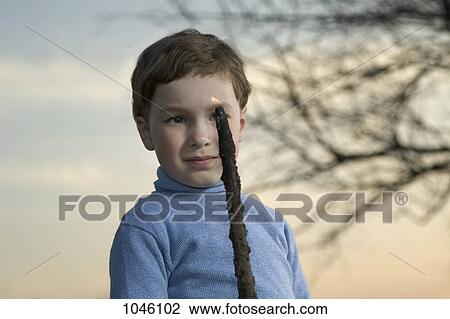 A young boy looking at a flame on the end of a stick View Large Photo Image Stock Image - A young boy looking at a flame on the end of a stick. Fotosearch