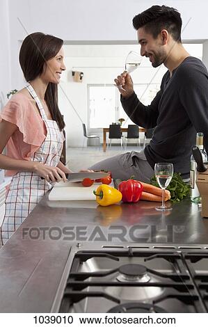 A young couple drinking wine and preparing food View Large Photo Image Stock Image - A young couple drinking wine and preparing food. Fotosearch