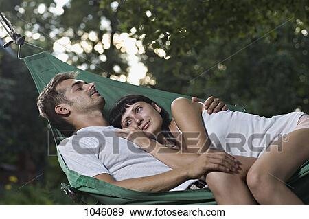 Stock Photo - A young couple lying together in a hammock. Fotosearch