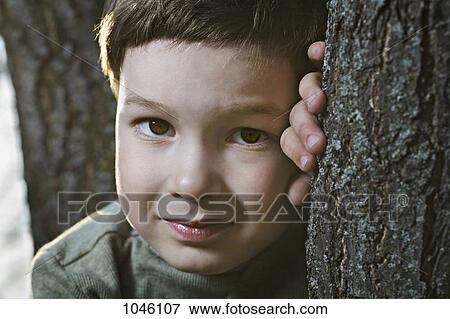 A young tired boy leaning on a tree View Large Photo Image Stock Photo - A young tired boy leaning on a tree. Fotosearch