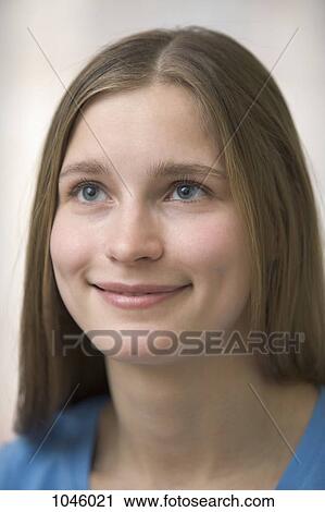 A young woman smiling while looking off camera View Large Photo Image Stock Image - A young woman smiling while looking off camera. Fotosearch
