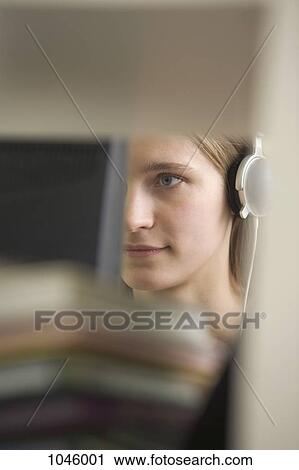 A young woman wearing headphones obscured by blurred objects View Large Photo Image Stock Image - A young woman wearing headphones obscured by blurred objects . Fotosearch