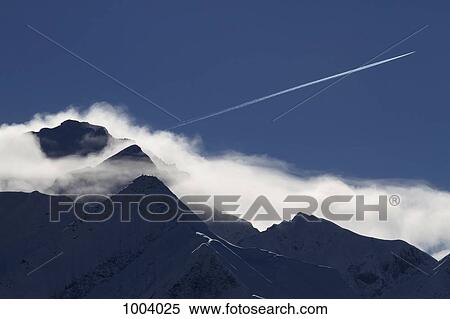 An airplane vapor trail over a mountain range, Graubunden Canton, Switzerland View Large Photo Image Stock Photography - An airplane vapor trail over a mountain range, Graubunden Canton, Switzerland. Fotosearch