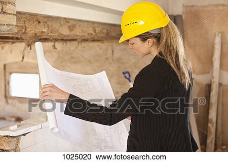 An architect reviewing blueprints at a building site View Large Photo Image Stock Image - An architect reviewing blueprints at a building site. Fotosearch