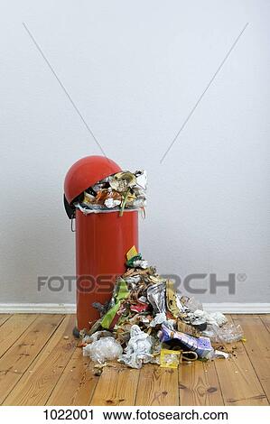 Stock Image - An overflowing garbage can of rotting food and recyclables. Fotosearch