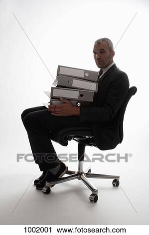 An overwhelmed looking businessman with a stack of binders View Large Photo Image Stock Image - An overwhelmed looking businessman with a stack of binders. Fotosearch