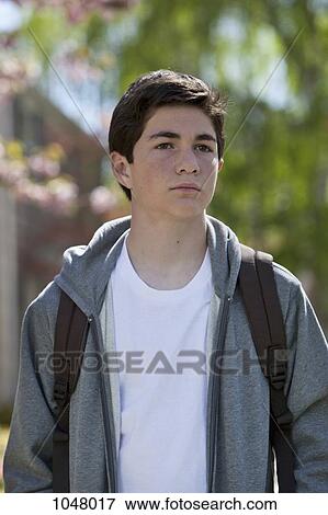 Boy standing still looking pensive wearing backpack View Large Photo Image Stock Photo - Boy standing still looking pensive wearing backpack. Fotosearch