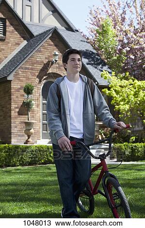 Boy walks on lawn holding his bike by his side View Large Photo Image Stock Image - Boy walks on lawn holding his bike by his side. Fotosearch