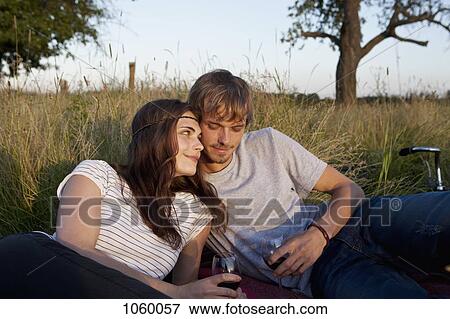 Boyfriend and girlfriend drinking wine in field View Large Photo Image Stock Photo - Boyfriend and girlfriend drinking wine in field. Fotosearch