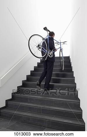 Business man returns home carrying bicycle up steps. View Large Photo Image Stock Image - Business man returns home carrying bicycle up steps.. Fotosearch