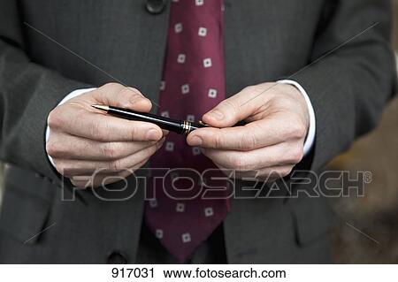 Businessman holding pen View Large Photo Image Stock Image - Businessman holding pen. Fotosearch