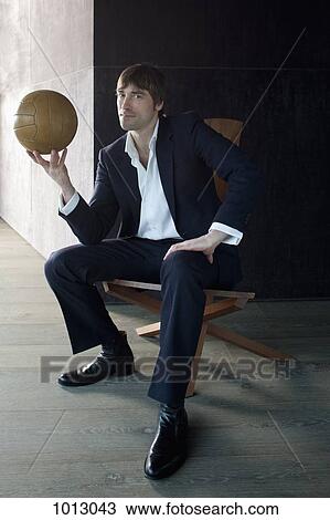 Businessman sitting holding soccer ball and looking at camera. View Large Photo Image Stock Image - Businessman sitting holding soccer ball and looking at camera.. Fotosearch