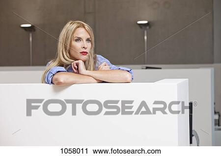 Businesswoman leaning on office cubicle and staring into distance View Large Photo Image Stock Image - Businesswoman leaning on office cubicle and staring into distance. Fotosearch