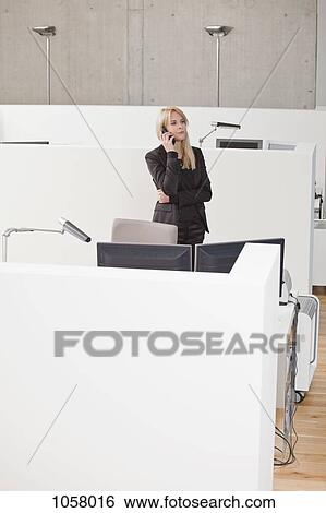 Businesswoman on phone at office cubicle View Large Photo Image Stock Photograph - Businesswoman on phone at office cubicle. Fotosearch