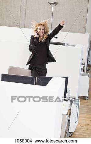 Businesswoman on phone jumping for joy in office cubicle View Large Photo Image Picture - Businesswoman on phone jumping for joy in office cubicle. Fotosearch