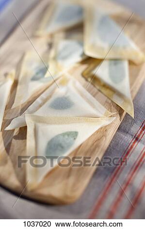 Stock Image - Cheese toast triangles on a chopping board. Fotosearch