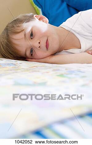 Stock Image - Close-up of a boy lying down. Fotosearch