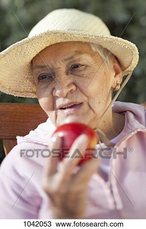Close-up of a senior woman holding an apple View Large Photo Image Stock Image - Close-up of a senior woman holding an apple. Fotosearch