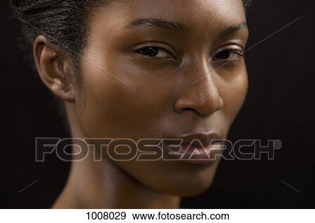Stock Photo - Close-up of a young woman scowling. Fotosearch