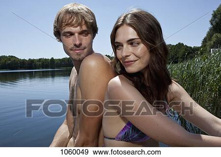 Couple back to back by the lake View Large Photo Image Stock Photo - Couple back to back by the lake. Fotosearch