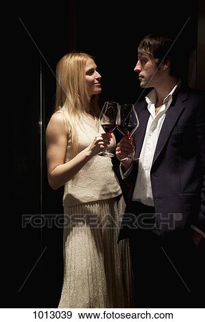 Stock Photo - Couple make a toast with red wine.. Fotosearch