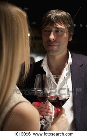 Couple make a toast with red wine. View Large Photo Image Stock Photograph - Couple make a toast with red wine.. Fotosearch