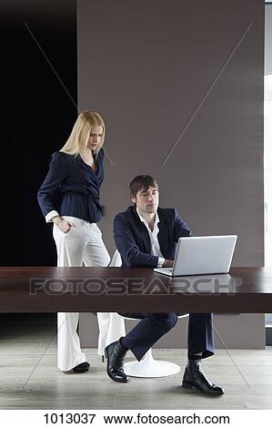 Stock Photo - Couple work from home and concentrate on laptop.. Fotosearch