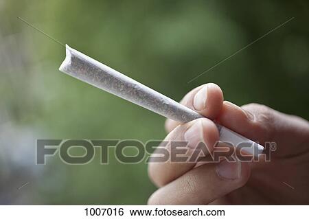 Stock Photograph - Detail of a man holding a joint. Fotosearch