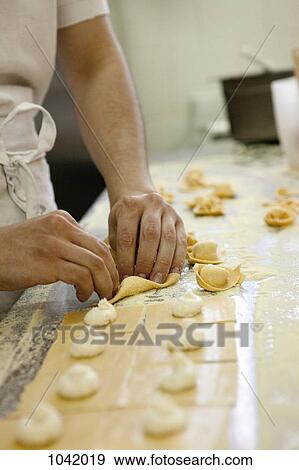 Stock Photo - Detail of a man making tortellini. Fotosearch