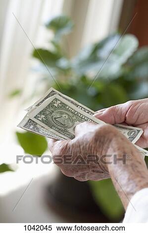 Detail of a senior woman holding US banknotes View Large Photo Image Stock Photography - Detail of a senior woman holding US banknotes. Fotosearch