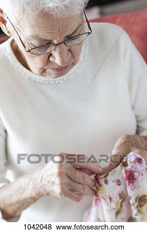 Detail of a senior woman stitching fabric View Large Photo Image Stock Photo - Detail of a senior woman stitching fabric. Fotosearch
