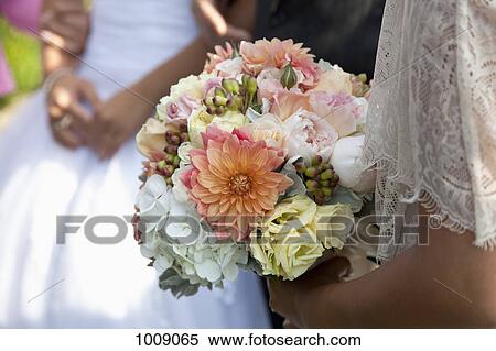 Detail of a woman holding a bouquet of flowers at a wedding View Large Photo Image Stock Photography - Detail of a woman holding a bouquet of flowers at a wedding. Fotosearch