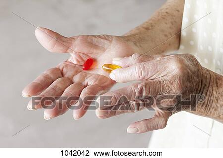 Detail of capsules in the hands of a senior woman View Large Photo Image Stock Image - Detail of capsules in the hands of a senior woman. Fotosearch