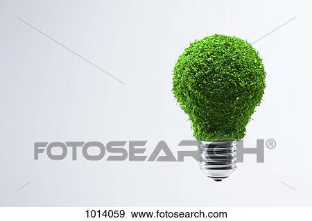Stock Photo - Energy saving light bulb covered in green grass. Fotosearch