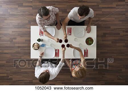 Four friends toasting at a dinner party, overhead view View Large Photo Image Stock Image - Four friends toasting at a dinner party, overhead view. Fotosearch