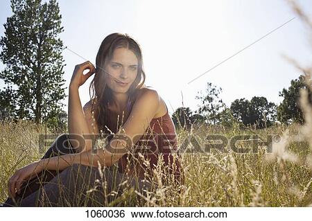 Girl sitting amongst timothy grass in the sunshine playing with her hair View Large Photo Image Stock Photograph - Girl sitting amongst timothy grass in the sunshine playing with her hair. Fotosearch