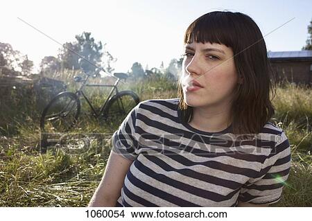 Girl sitting in secluded field exhaling smoke View Large Photo Image Picture - Girl sitting in secluded field exhaling smoke. Fotosearch