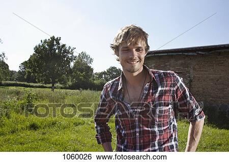 Guy in field with barn in background View Large Photo Image Stock Photograph - Guy in field with barn in background. Fotosearch