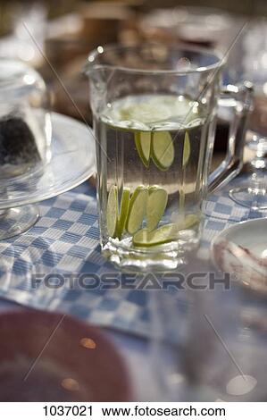 Jug of water with sliced lime on dining table outside View Large Photo Image Stock Image - Jug of water with sliced lime on dining table outside. Fotosearch