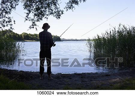 Man fishing by lake View Large Photo Image Picture - Man fishing by lake. Fotosearch